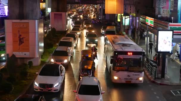 BANGKOK, THAILAND - 18. prosince 2018: Auta v dopravní zácpě na silnici přelidněného asijského hlavního města Thajska v noci. žlutá a červená elektrická světla, tuk tuky, autobusy — Stock video