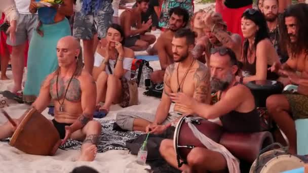 泰国帕岸岛-2019年2月23日禅宗海滩。快乐的人在日落时在热带天堂夏季海岸上弹吉他和鼓, 周围有许多人。音乐障碍, 自由概念, 社交休闲 — 图库视频影像