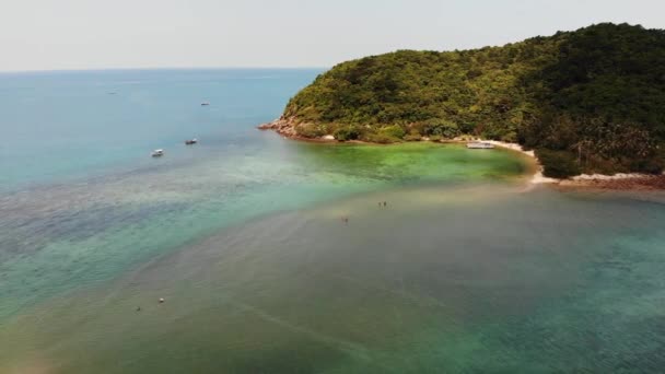 Dron powietrzny widok małej wyspy Koh Ma, Ko Phangan Tajlandii. Egzotyczny krajobraz wybrzeża, plaża Mae Haad, letni dzień. Piaszczysta ścieżka między koralowcami. Żywy krajobraz morski, górskie palmy kokosowe z góry. — Wideo stockowe