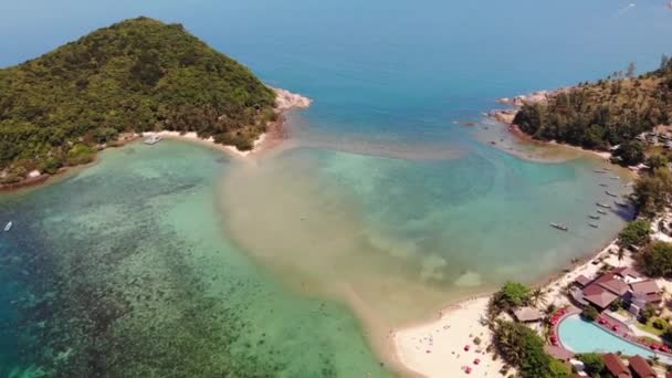 Flygdrönare visa små Koh Ma ön, Ko Phangan Thailand. Exotiskt kustlandskap, Mae Haad stranden, sommardag. Sandväg mellan koraller. Vivid havslandskap, kokospalmer från ovan. — Stockvideo