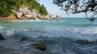 Güzel denizin yanındaki yeşil uçurum. Güneşli bir günde Tayland 'da Ko Phangan' ın engebeli yeşil uçurumunda dalgalanan görkemli mavi deniz. Egzotik Tropik Cennet Sahili.