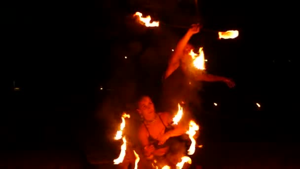 PHANGAN, THAILAND - 23 e.Kr. 2019 Thailändsk eldgivning. Brandprestanda hos lokala akrobater. Farliga trick med lågor. Konstnärer dansar med ljus i mörka natten, underhållning för turister. man och kvinna, — Stockvideo