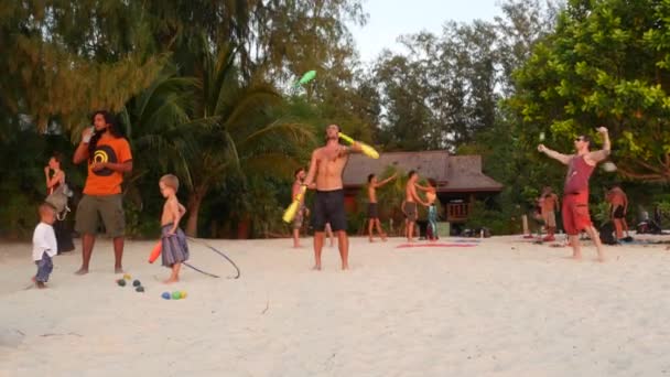 PHANGAN, ThAILAND - 23 e.Kr. Zen Beach 2019. Unge man tränar för att jonglera på den tropiska paradisstranden bland ett stort antal människor vid solnedgången. Frihetskoncept, social fritid, cirkus show — Stockvideo