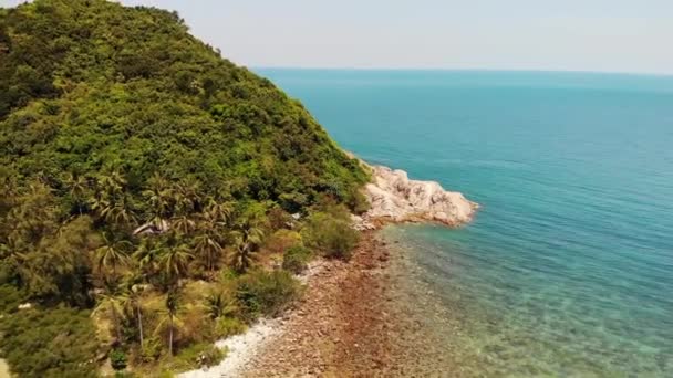 Dron powietrzny widok małej wyspy Koh Ma, Ko Phangan Tajlandii. Egzotyczny krajobraz wybrzeża, plaża Mae Haad, letni dzień. Piaszczysta ścieżka między koralowcami. Żywy krajobraz morski, górskie palmy kokosowe z góry. — Wideo stockowe