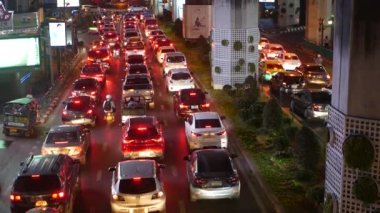 BANGKOK, THAILAND - 18 ARALIK, 2018: aşırı kalabalık Tayland 'ın başkenti Tayland yolunda gece trafikte sıkışan arabalar. sarı ve kırmızı elektrik lambaları, tuk tuk, otobüsler