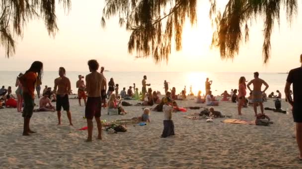 PHANGAN, THAÏLANDE - 23 FEVRIER 2019 Zen Beach. Jeune homme s'entraîne à jongler sur la plage tropicale paradisiaque parmi un grand nombre de personnes au coucher du soleil. Concept de liberté, loisirs sociaux, spectacle de cirque — Video