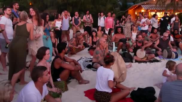 Phangan, Thajsko - 23 února 2019 Zen Beach. Šťastní lidé hrát na kytaru a bicí na tropický ráj letní pobřeží při západu slunce, obklopené mnoha lidí. Hudební jam, pojetí svobody, sociální volný čas — Stock video