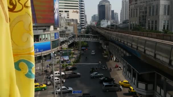 BANGKOK, TAILANDIA - 18 DE DICIEMBRE DE 2018: Tren en la calle de la ciudad. Tren moderno a caballo en el puente ferroviario sobre la carretera con coches en la calle moderna increíble. Bandera amarilla real ondeando en el viento — Vídeo de stock