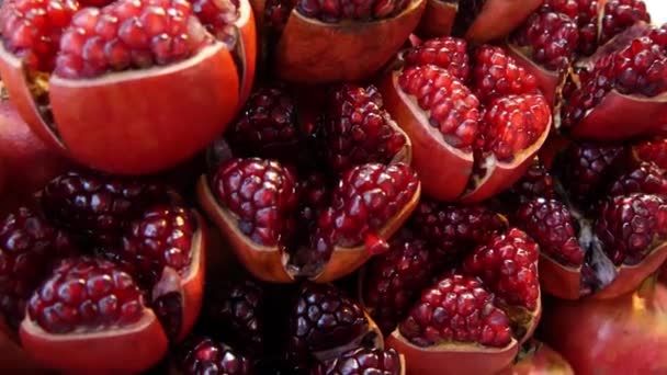 Halves of ripe pomegranates for juice. Heap of halves of yummy ripe pomegranates for fresh juice placed on stall — Stock Video