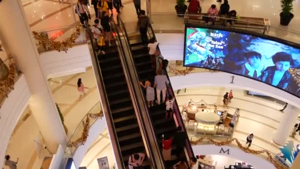 BANGKOK, TAILANDIA - 18 DE DICIEMBRE DE 2018: Siam Paragon centro comercial asiático interior. Multitud de personas en las escaleras mecánicas del centro comercial. La gente se apresura a ir de compras en plaza moderna. Consumo de bienes — Vídeo de stock