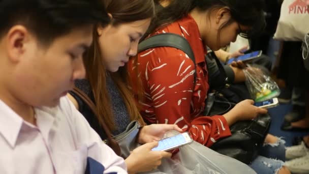 BANGKOK, THAILAND - 18 ΔΕΚΕΜΒΡΙΟΥ, 2018: Επιβάτης στο σταθμό BTS Skytrain στην Μπανγκόκ της Ταϊλάνδης, όλοι κοιτάζουν προς τα κάτω το smartphone ενώ περιμένουν το BTS skytrain — Αρχείο Βίντεο