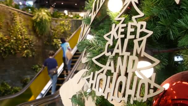 BANGKOK, THAILAND - 18 DE DEZEMBRO DE 2018: EmQuartier asiático shopping center interior. As pessoas em escadas rolantes do centro de comércio apressam-se a fazer compras, praça contemporânea moderna. Decoração de Natal. árvore de ano novo. — Vídeo de Stock