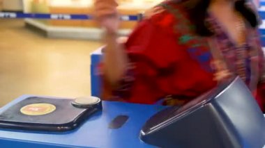 Tren istasyonuna giriş kartı kullanan isimsiz insanlar. Kırpılan insanlar, Skytrain istasyonuna girerken turnikelerde plastik araba kullanıyorlar..