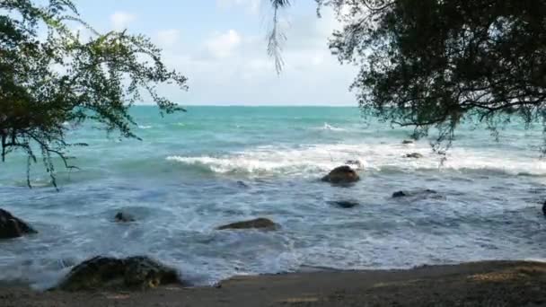 树木和美丽的大海。在泰国，阳光明媚的日子里，雄伟的蓝色大海在高山上的树木后面荡漾。异国情调热带天堂海滩. — 图库视频影像