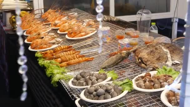 Esotici asiatici nazionali pronti a mangiare frutti di mare di notte street market food court in Thailandia. Deliziosi gamberetti alla griglia o gamberetti e altri snack. — Video Stock