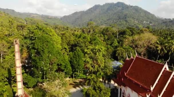 Klassieke boeddhistische tempel tussen bos. Van boven drone uitzicht klassieke boeddhistische klooster tussen groene bomen in de buurt van heuvel in Thailand. Koh Samui. concept van toerisme, meditatie en het oosterse leven. — Stockvideo