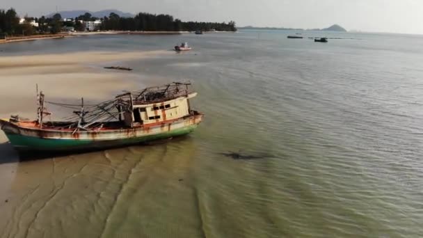 Fiskefartyg på sand kusten nära vatten. Gamla öde rostig fiskebåt på sandstrand nära havet i soliga dagar, Koh Samui antenn Drone View. — Stockvideo