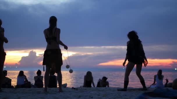 PHANGAN, TILLAND - 23 Mars 2019 Zen Beach. Silhuetter av artister på stranden under solnedgången. Silhuetter av unga anonyma underhållare repeterar på sandstrand mot lugnt hav och solnedgång himmel. — Stockvideo