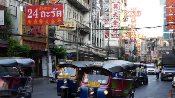 BANGKOK, THAILAND - 18. MÄRZ 2019: Tuk Tuks auf den Straßen einer asiatischen Stadt. Bunte Auto-Rikschas fahren auf Asphaltstraße auf belebter Straße von Chinatown in Bangkok. — Stockvideo