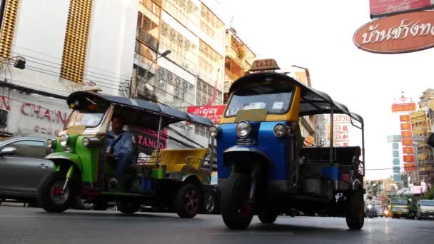 BANGKOK, THAILAND - 18. MÄRZ 2019: Tuk Tuks auf den Straßen einer asiatischen Stadt. Bunte Auto-Rikschas fahren auf Asphaltstraße auf belebter Straße von Chinatown in Bangkok. — Stockvideo