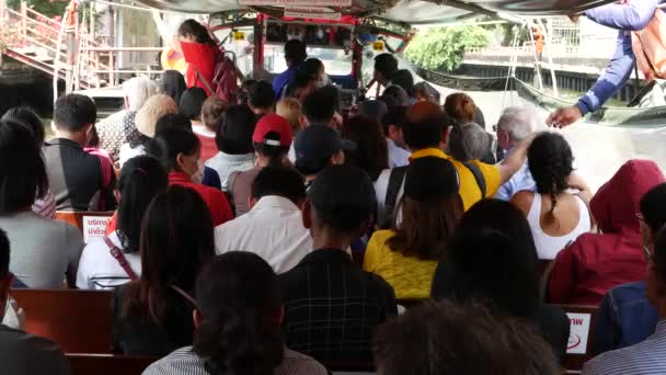 BANGKOK, THAILAND - 18. MÄRZ 2019: Wat Sri Bunruang Wassertor. Anonyme Bootsflüchtlinge. Rückansicht von Menschen, die an sonnigen Tagen auf öffentlichen Flussschiffen unterwegs sind. Kanäle in Krungtep. — Stockvideo