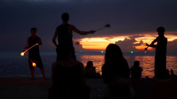 PHANGAN, TAILANDIA - 23 DE MARZO DE 2019 Zen Beach. Siluetas de intérpretes en la playa durante el atardecer. Siluetas de jóvenes artistas anónimos ensayando en la playa de arena contra el mar tranquilo y el cielo al atardecer. — Vídeos de Stock