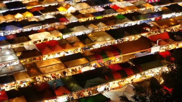 Illuminated tents of market at night. Top view of colorfull brightly illuminated tents of Ratchada Rot Fai Train Night Market on tourist street of Bangkok. Popular attraction, streetfood and shoping — Stock Video