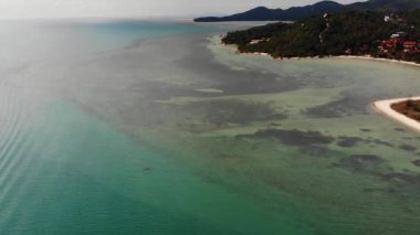 Tropik adanın plajları na yakın mavi deniz. Tropikal egzotik cennet Ko Phangan Adası turistik plajları yakınında sakin mavi deniz nefes kesen drone görünümü. Tayland.