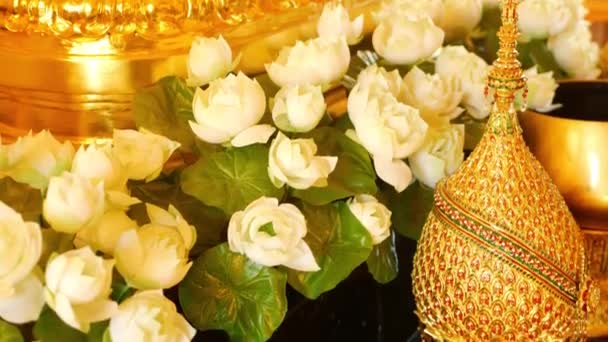 제단에 꽃과 황금 장식. 태국의 전통적인 제단에 배치 아름다운 흰색 연꽃과 황금 왕실 장식품. 군주제의 상징. — 비디오
