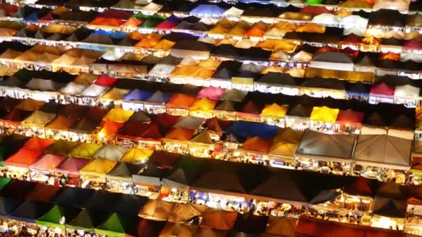 Illuminated tents of market at night. Top view of colorfull brightly illuminated tents of Ratchada Rot Fai Train Night Market on tourist street of Bangkok. Popular attraction, streetfood and shoping — Stock Video