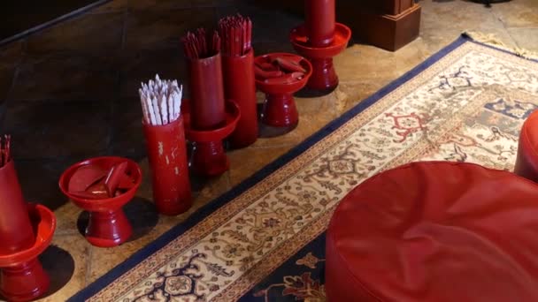 Es bleibt bei Vorhersagen im orientalischen Tempel. Vasen mit traditionellen Naht-si Wahrsagerstöcken, die in einem chinesischen Tempel vor dem Altar auf dem Boden stehen. Kissen für die Knie auf dem Boden auf Teppich — Stockvideo