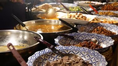 Çeşitli Asya yemekleri olan kaseler. Akşamları sokak lokantasının tezgahına çeşitli geleneksel Tayland yemekleri koyuyorlar. Doğulu gece marketi yemek katı.