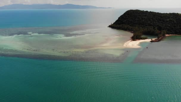 Tropische Insel im Meer. wunderbarer Drohnenblick auf grüne tropische Insel inmitten ruhigen blauen Meeres mit Korallen unter der Wasseroberfläche. — Stockvideo