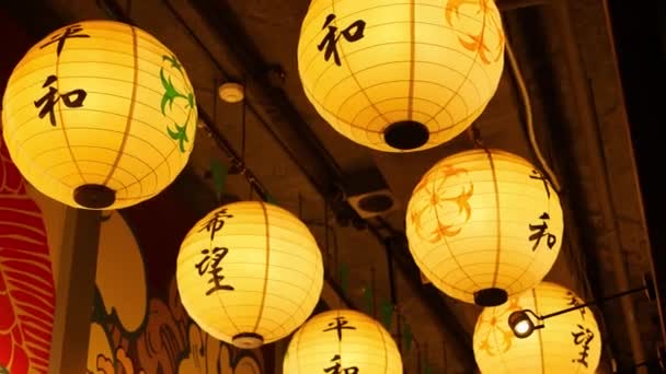 Paper lanterns shining on street. Beautiful paper lanterns shining while hanging in narrow passage on Japanese street. Oriental decor. — Stock Video