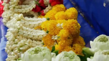 Sunak için çiçek çelenkleri. Pazar tezgahına yerleştirilen satılık ritüel kurban için çeşitli çiçek çelenk