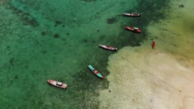 Resife yakın balıkçı tekneleri. Muhteşem mercan resiflerinin yakınında mavi deniz suyunda yüzen balıkçı teknelerinin güzel hava manzarası. Doğal egzotik cennet arka planı. Koh Phangan Samui, Tayland.