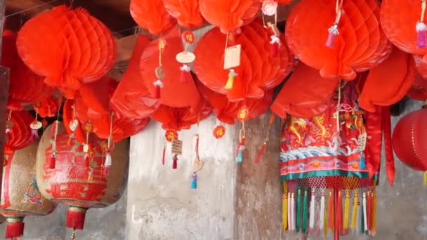 Lanternes en papier sur bâtiment minable. Lanternes en papier rouge suspendues au plafond du bâtiment du temple en béton altérée par une journée ensoleillée dans le pays oriental. décoration traditionnelle — Video