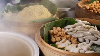 Lokantada çeşitli Asya yemekleri var. Tahta kaseler ve çeşitli geleneksel Tayland yemekleri. Şehirdeki bir lokantada satılıyor..