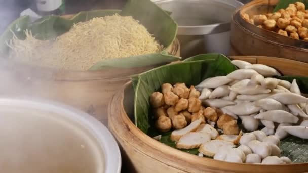 Mísy s různými asijskými pokrmy v bistru. Dřevěné mísy s výběrem tradičních thajských jídel na prodej umístěné na stánku pouličního bistra ve městě. — Stock video
