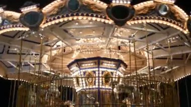 Işıklı neşeli parkta yuvarlak gidin. Geceleri harika bir eğlence parkında dönen parlak ışıklı kavşak