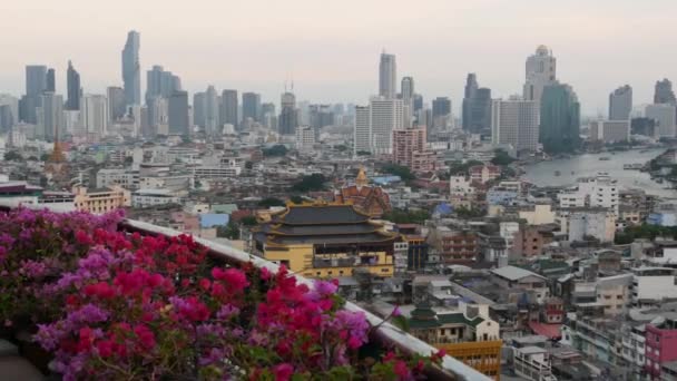 Kilátás a hagyományos és modern épületek keleti város. Gyönyörű virágágyás ellen városkép hagyományos házak és felhőkarcolók ködös napon utcáin Bangkok vagy Krungtep. — Stock videók