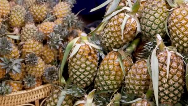 Frutas y verduras en un puesto rústico. Surtido de frutas y verduras frescas maduras colocadas en un puesto oriental rústico en el mercado. Piñas jugosas amarillas agridulces . — Vídeos de Stock