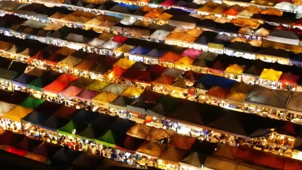 Tendas de mercado iluminadas à noite. Vista superior de tendas coloridas brilhantemente iluminadas de Ratchada Rot Fai Train Night Market na rua turística de Bangkok. Atração popular, streetfood e shoping — Vídeo de Stock