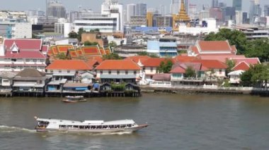 Krungthep şehrinde nehirde yüzen doğu teknesi. Çin Mahallesi yakınlarındaki Bangkok 'ta güneşli bir günde Chao Praya nehrinde yüzen modern nakliye gemisi. Panorama