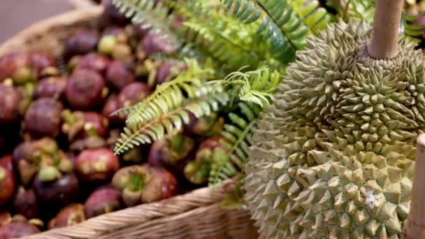 Gyümölcsök és zöldségek a rusztikus istállóban. Kiválasztott friss érett gyümölcsök és zöldségek a rusztikus keleti standon a piacon. édes trópusi lila mangosztán és durian előtérben. — Stock videók