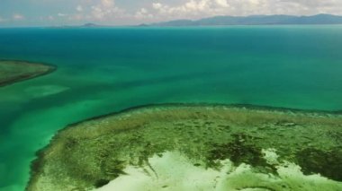 Muhteşem mercan resiflerinin manzarası. Tropik adanın kıyısına yakın sakin mavi deniz ve güzel mercan resifleri pitoresk drone görünümü. Cennet mercan adası
