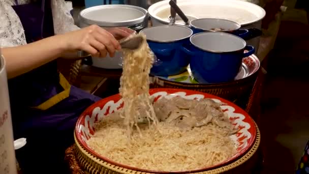 Crop woman doet noedels in een zak. Onherkenbare vrouwelijke verkoper zet traditionele Thaise noedels in plastic zak tijdens het werken in diner op straat — Stockvideo