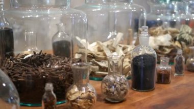 Eczacı dükkanında kurutulmuş otlar ile Kavanozlar. Retro oryantal eczanede rafa yerleştirilen çeşitli kurutulmuş ilaç otlar ile cam kavanoz ve şişeler