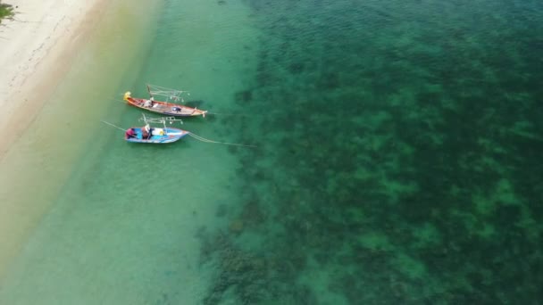 Barcos de pesca perto do recife. Bela vista aérea de barcos de pesca flutuando na água do mar azul perto do majestoso recife de coral. Fundo paradisíaco exótico natural. Koh Phangan Samui, Tailândia. — Vídeo de Stock