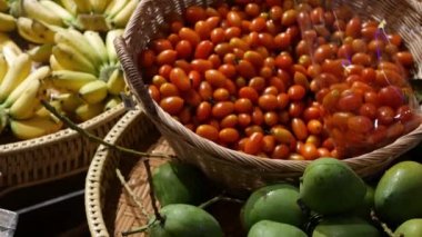 Meyve ve sebzeler köy tezgahında. Marketteki kırsal kesimlere yerleştirilmiş taze meyve ve sebzeler. Yeşil mango, domates ve sarı muz..
